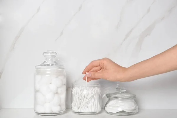 Young woman taking cotton swab from jar indoors, closeup — 스톡 사진