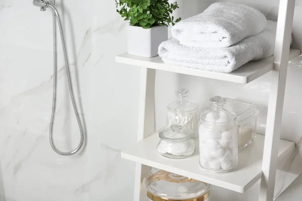 Unidad de estanterías con bolas de algodón, hisopos y almohadillas en el baño —  Fotos de Stock