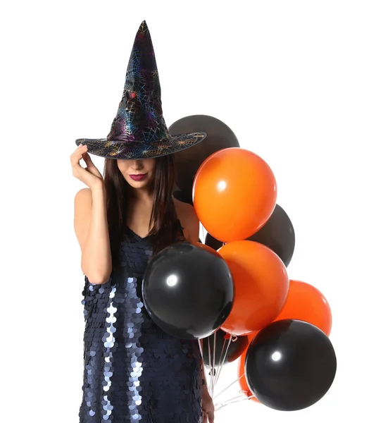 Schöne Frau trägt Hexenkostüm mit Luftballons für Halloween-Party auf weißem Hintergrund — Stockfoto