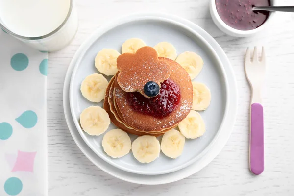 Pancake lezat disajikan dengan selai dan susu di meja kayu putih, berbaring datar. Ide kreatif untuk sarapan anak-anak — Stok Foto