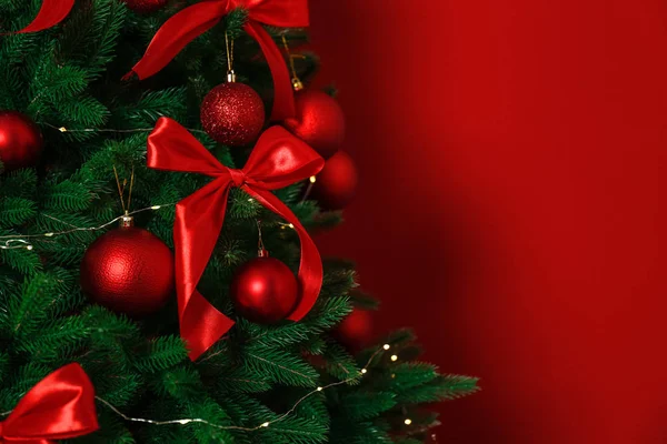 Διακοσμημένο χριστουγεννιάτικο δέντρο σε κόκκινο φόντο, κοντινό. Χώρος για κείμενο — Φωτογραφία Αρχείου