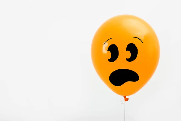 Orangefarbener Luftballon mit Zeichnung eines verängstigten Gesichts auf hellem Hintergrund, Platz für Text. Halloween-Party — Stockfoto