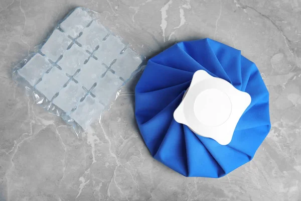 Composition with ice pack on marble table, flat lay — 스톡 사진