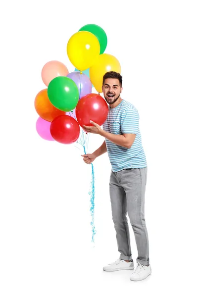 Jeune homme émotionnel tenant un tas de ballons colorés sur fond blanc — Photo