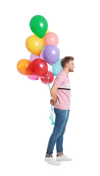 Joven sosteniendo racimo de globos de colores sobre fondo blanco — Foto de Stock
