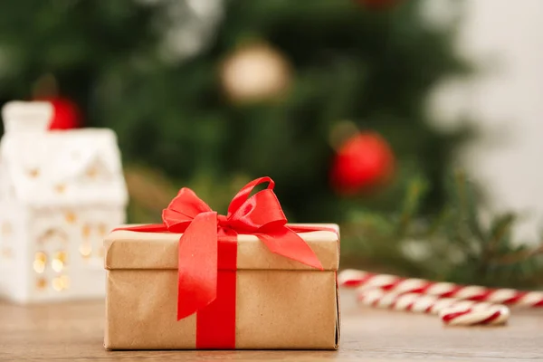 Christmas gift on table against blurred background — Stock Photo, Image