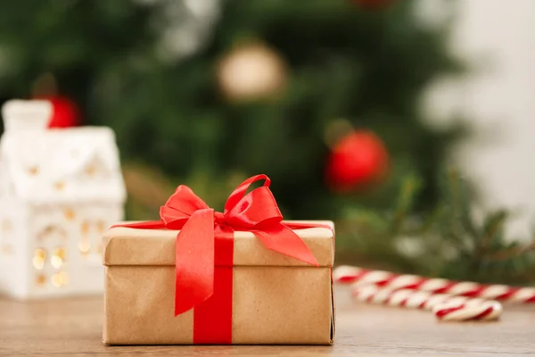 Presente de Natal na mesa contra fundo desfocado — Fotografia de Stock