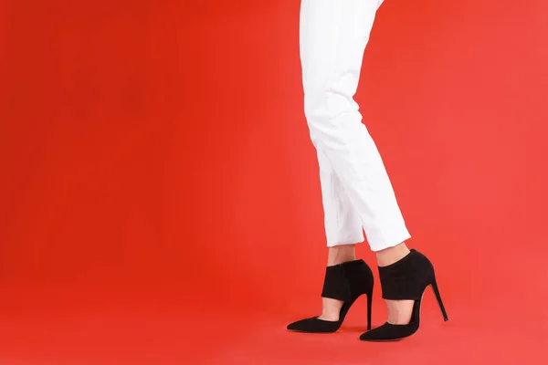 Vrouw met elegante schoenen op rode achtergrond. Ruimte voor tekst — Stockfoto