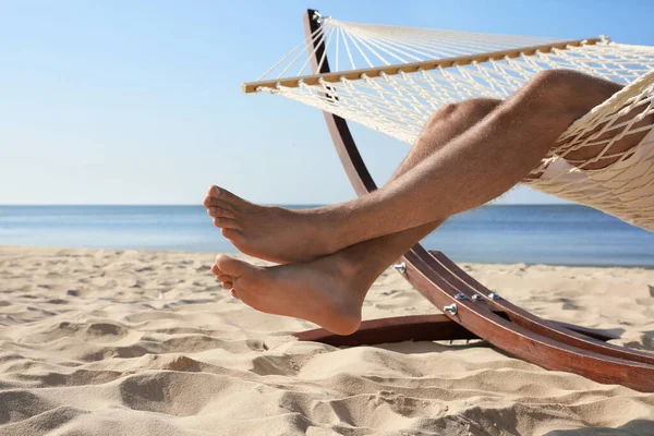 Giovane uomo che si rilassa in amaca sulla spiaggia, primo piano — Foto Stock