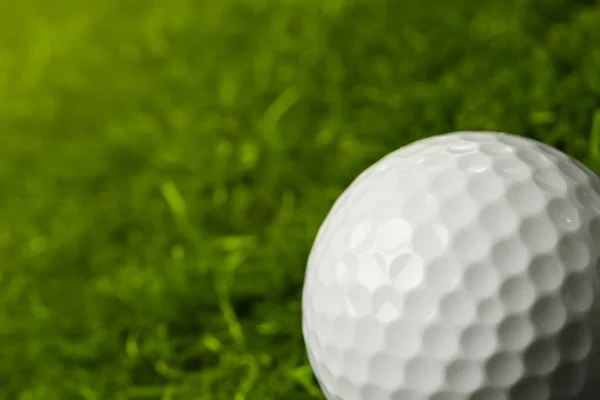 Piłka golfowa na zielonym polu na zewnątrz, zbliżenie. Miejsce na tekst — Zdjęcie stockowe