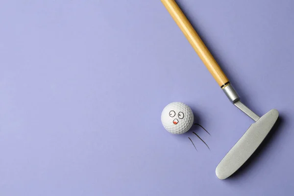 Piłka golfowa z zabawną twarzą odlatująca z klubu na liliowym tle - kreatywny wizerunek. Widok z góry — Zdjęcie stockowe
