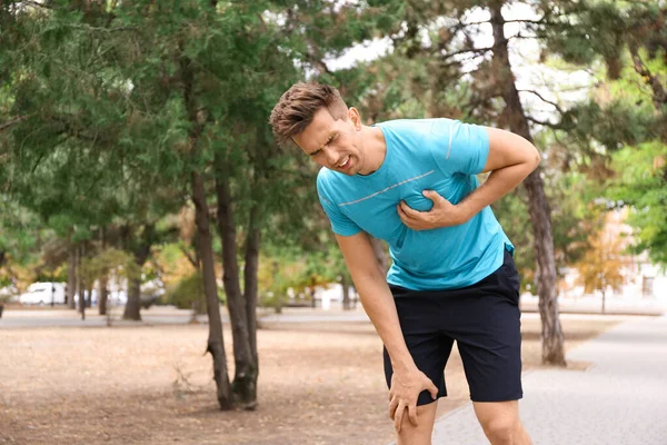 Joven teniendo un ataque al corazón mientras corría en el parque — Foto de Stock