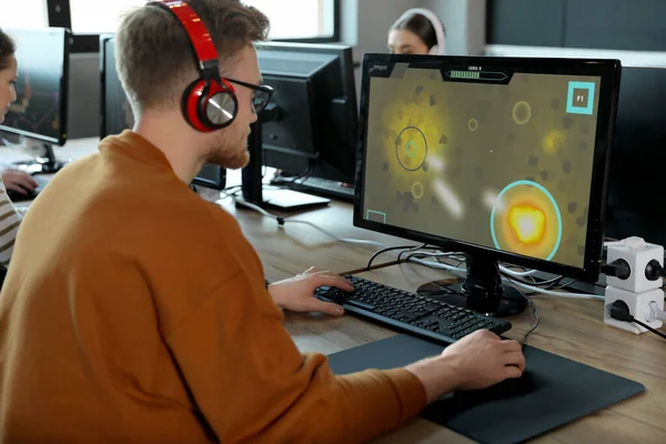 Мужчина играет в видеоигры в интернет-кафе — стоковое фото