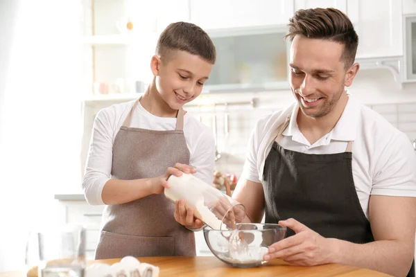 Dad and son cooking together in kitchen