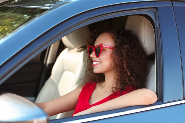 Giovane bella donna afroamericana che indossa occhiali a forma di cuore in auto — Foto Stock