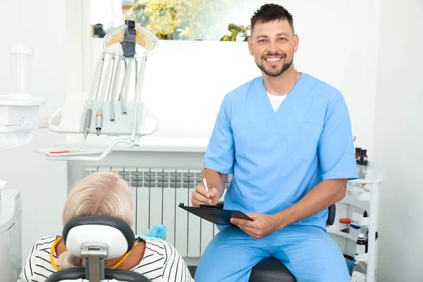 Professionele tandarts werkt met patiënt in kliniek — Stockfoto