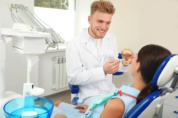 Dentista profissional mostrando modelo de mandíbulas de paciente na clínica — Fotografia de Stock