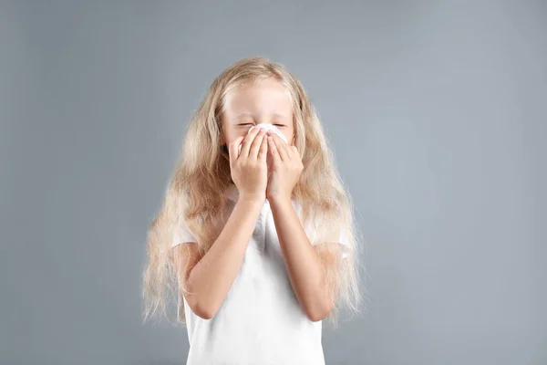 Bambina che soffre di allergia su sfondo grigio — Foto Stock