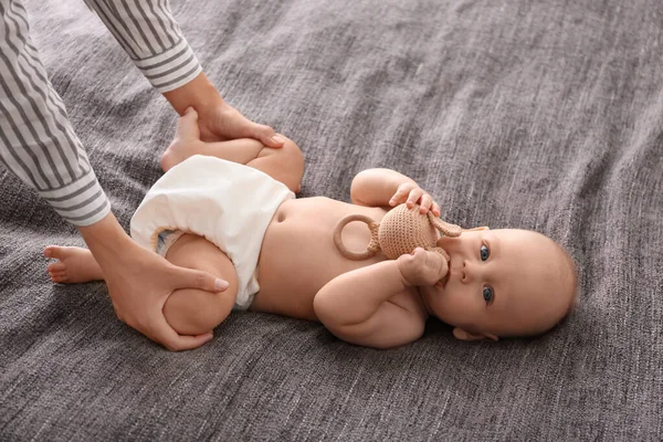 Jonge vrouw masserende schattige kleine baby op deken — Stockfoto