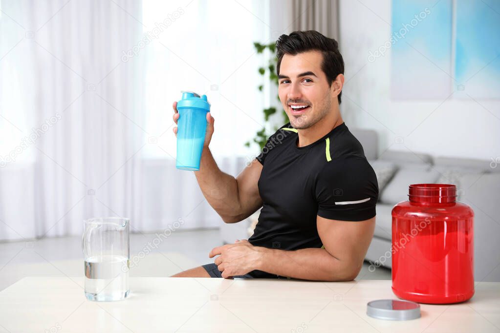 Young athletic man with protein shake at home, space for text