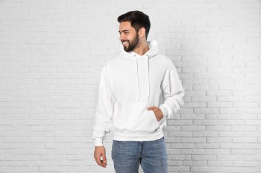 Tuğla duvarda kazak genç adamın portresi. Tasarım için alay