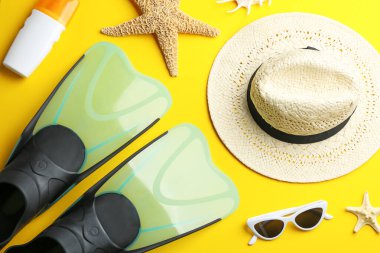 Düz kompozisyon ve sarı arka planda plaj aksesuarları.