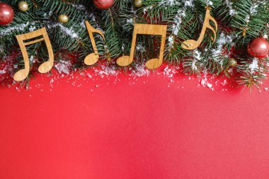 Kırmızı arka plan üzerinde Noel dekor ve müzik notaları ile Düz yatıyordu kompozisyon, metin için alan