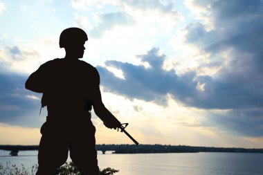 Dışarıda devriye gezen makineli tüfekli bir asker. Askerlik hizmeti
