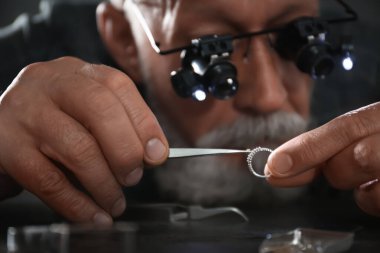 Atölyede elmas yüzük değerlendiren erkek kuyumcu, closeup görünümü