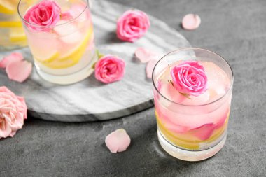 Gri masada limon ve güllerle nefis ferahlatıcı bir içecek.