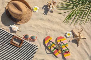 Kum üzerinde farklı plaj aksesuarları ile yapılan çerçeve, üst görünüm. Metin için alan