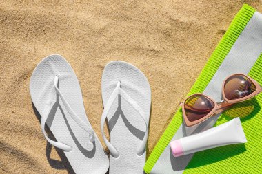 Kum üzerinde farklı plaj aksesuarları ile düz döşeme kompozisyon