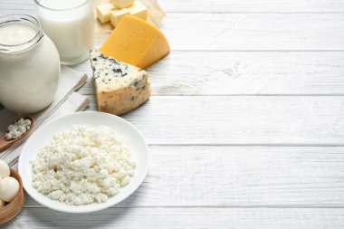 Beyaz ahşap masada farklı süt ürünleri. Metin için boşluk