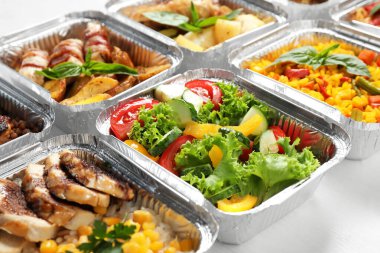 Beyaz tahta masanın üzerinde yemek kutuları, yakın çekim. Sağlıklı gıda dağıtımı