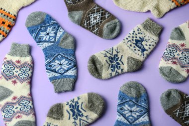 Menekşe arka planda farklı örülmüş çoraplar, düz yatış. Kış giysileri