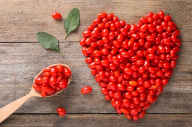 Düz kompozisyonda taze, olgun goji üzümleri ahşap masada duruyordu.