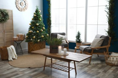Güzel bir iç mekan, oturma odasında süslü Noel ağacı var.