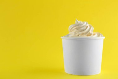 Sarı arka plan üzerinde lezzetli dondurulmuş yoğurt ile Fincan. Metin için alan