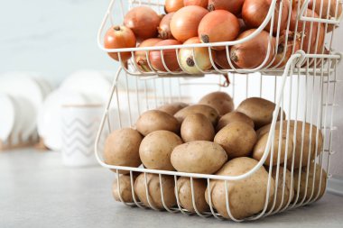 Gri mutfak tezgahında patates ve soğanlı konteynır. Düzenli depo