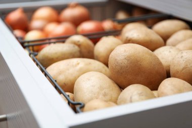 Patates ve soğanlı açık çekmece, yakın plan. Düzenli depo