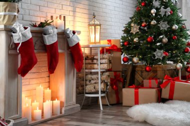Dekoratif şöminesi ve Noel ağacı olan şenlik odası.