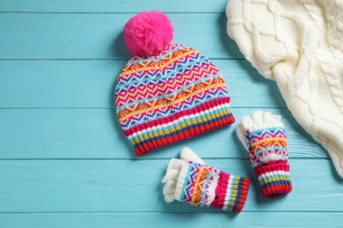 Mavi ahşap arka planda sıcak örülmüş giysiler, düz yatış.