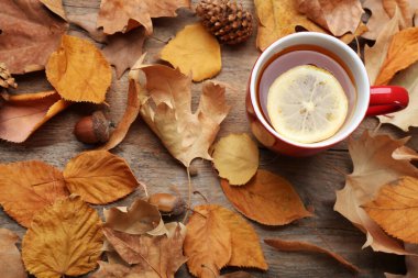 Düz kompozisyon ve bir fincan sıcak içecekle ahşap masanın üzerinde yatıyordu. Sıcak sonbahar atmosferi