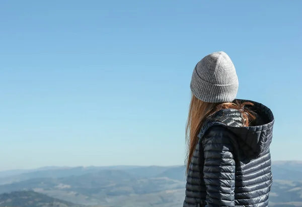 Mulher em roupas quentes olhando para a bela paisagem da montanha — Fotografia de Stock