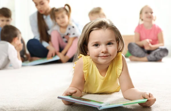 Söt liten barn med bok inomhus, utrymme för text. Lära och spela — Stockfoto