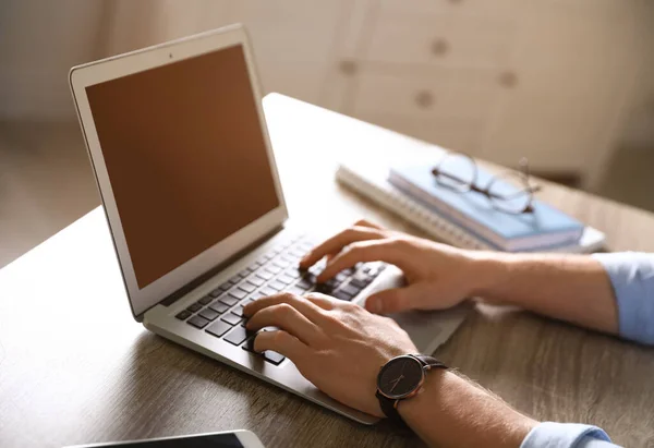 Hombre usando el portátil en la mesa en el interior, primer plano. Espacio para texto — Foto de Stock