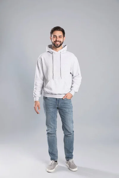 Ganzkörperporträt eines jungen Mannes im Pullover auf grauem Hintergrund. Mock up für Design — Stockfoto