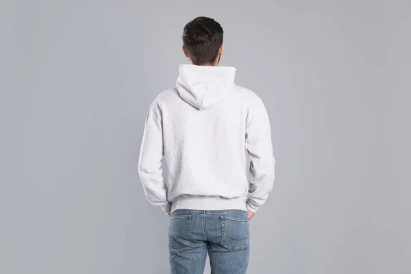 Jonge man in trui op grijze achtergrond. Mock up voorontwerp — Stockfoto