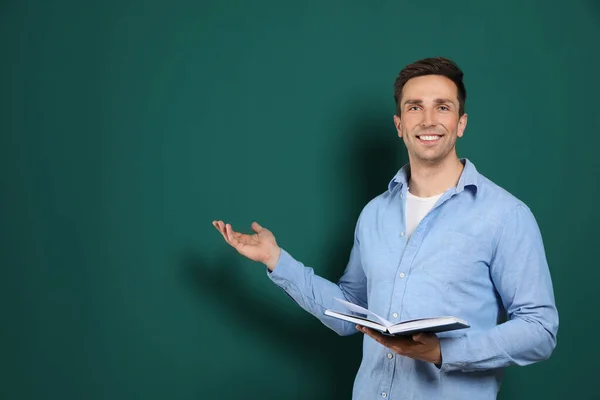 Retrato de maestro varón con libro sobre fondo de color. Espacio para texto — Foto de Stock