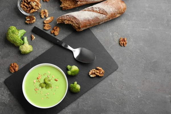 Composition plate avec bol de soupe à la crème de brocoli sur table grise, espace pour le texte — Photo